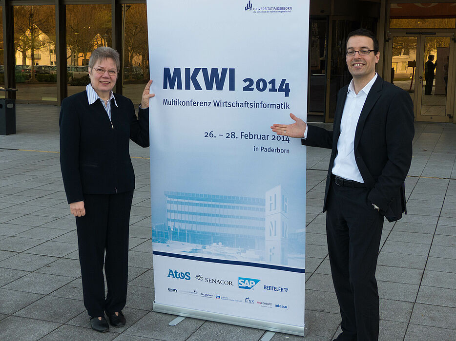 Foto (Universität Paderborn): Die Tagungsleiter Prof. Dr. Leena Suhl und Prof. Dr. Dennis Kundisch präsentieren das Programm der Multikonferenz Wirtschaftsinformatik (MKWI).